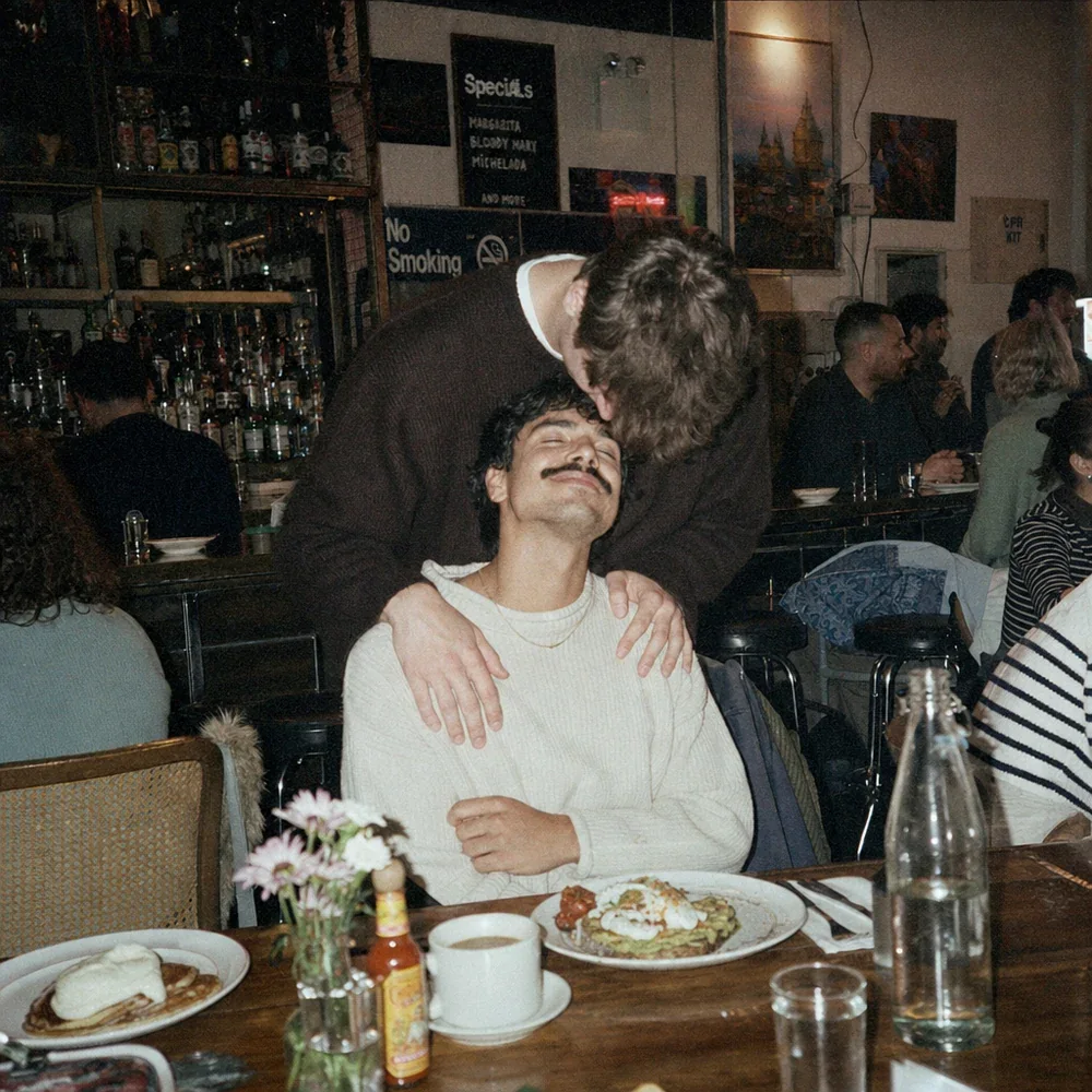 A couple sharing a tender moment over brunch in a restaurant