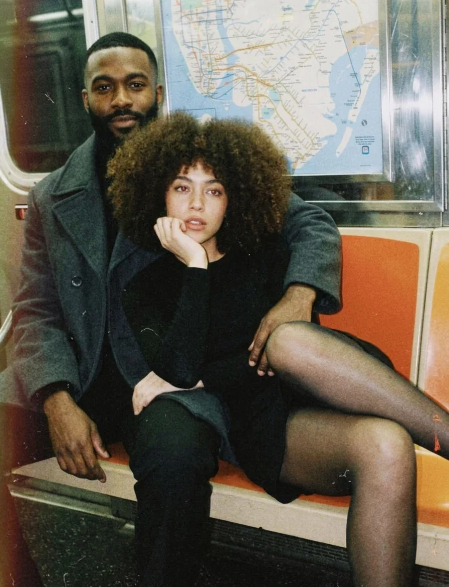 A couple sitting close together on the subway