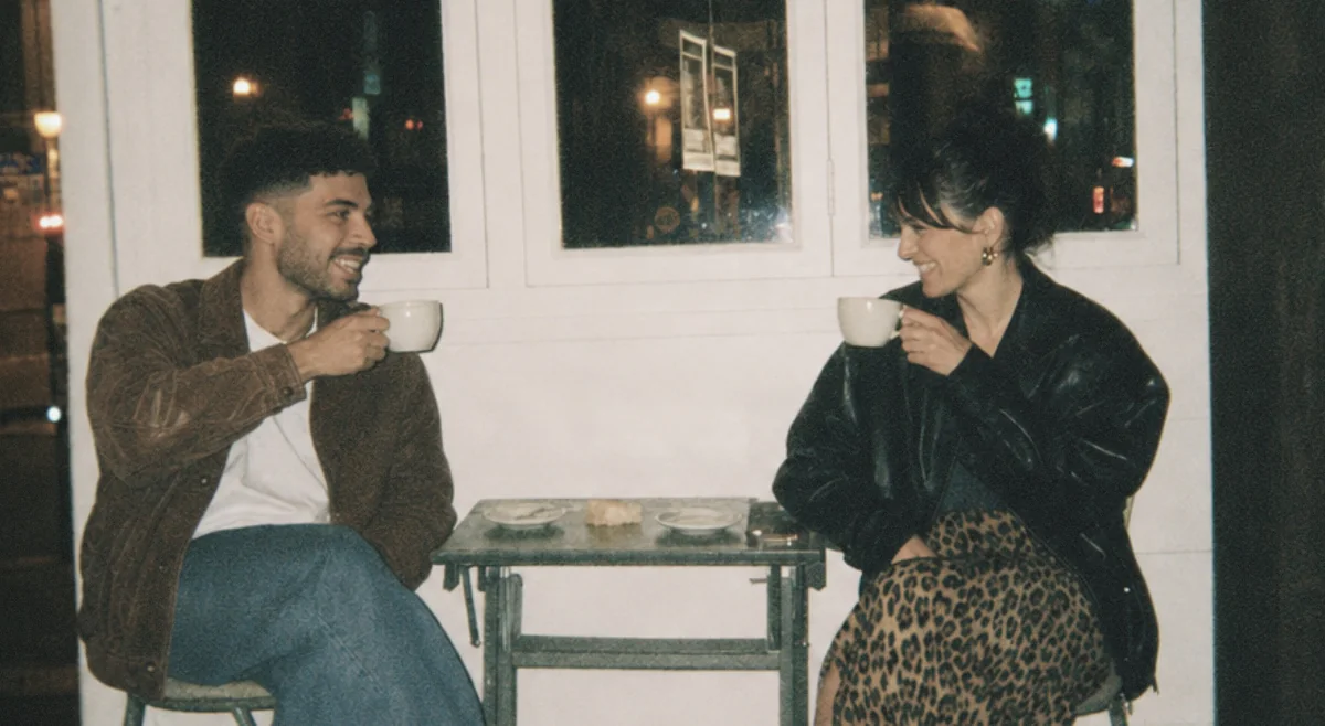 Two people sharing coffee outside a café